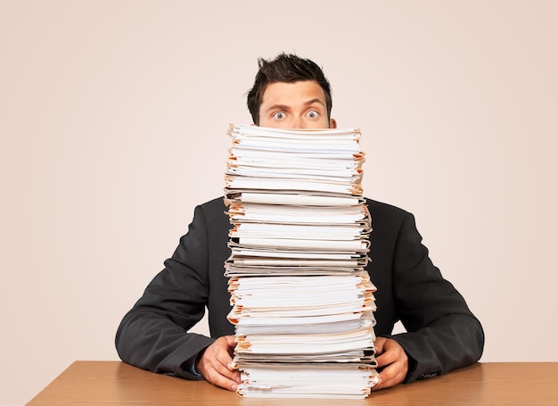 Young businessman with stack of papers