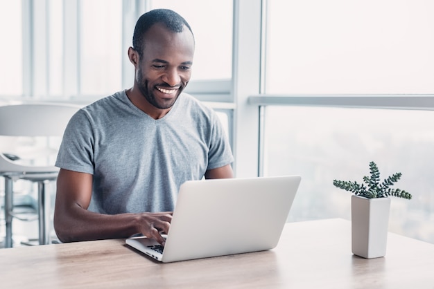 Young businessman working on his laptop in spacious bright office