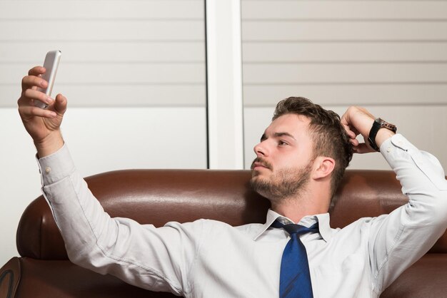 Young businessman working in his office while talking on the phone