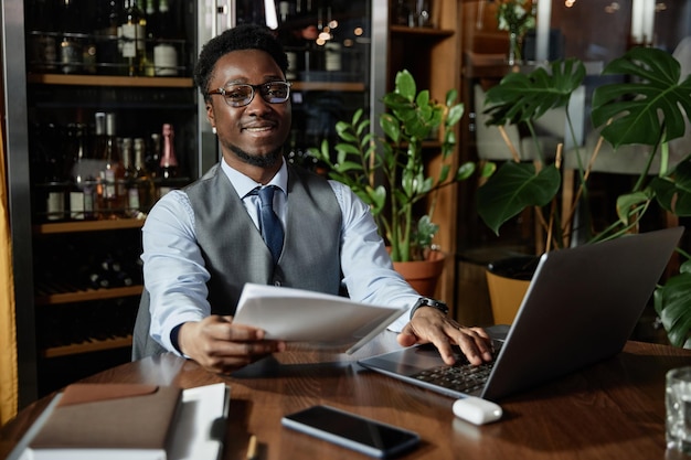 Young businessman working on laptop in cafe