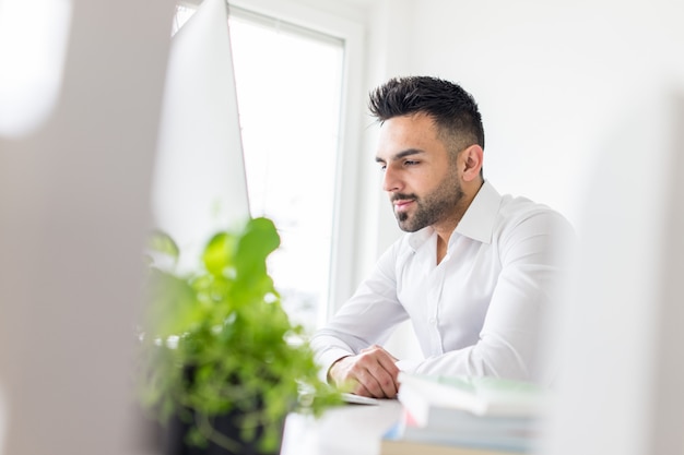 Young businessman working at office on computer desk