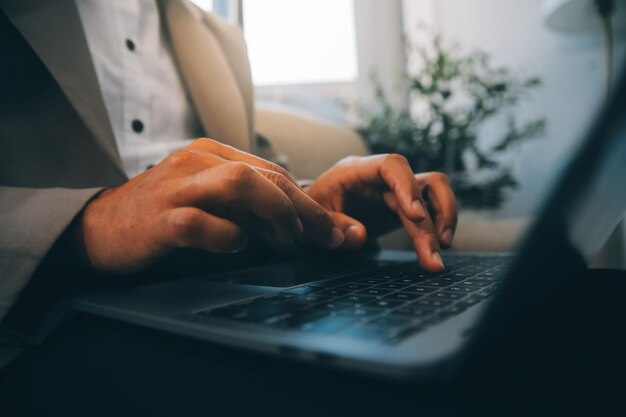 Photo young businessman working in office sitting at desk looking at laptop computer screen