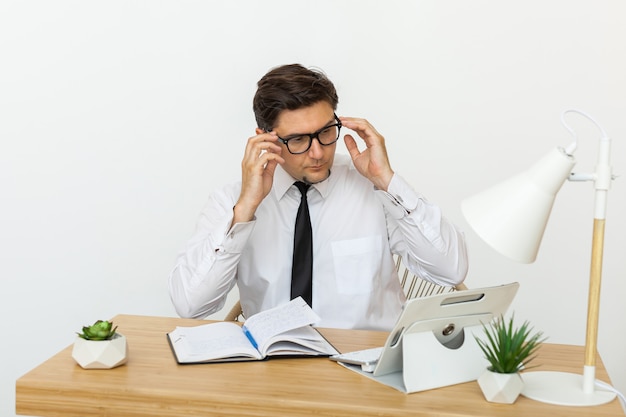 Young businessman working in office, sitting at desk