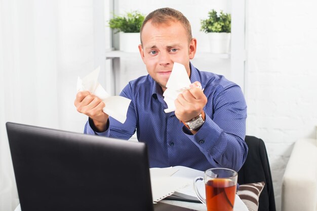 Young businessman working in the office very concerned a panic crumpled paper