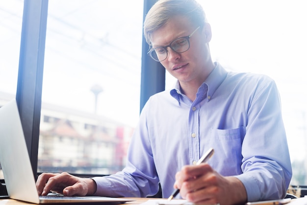 young businessman working with mobile laptop and documentsin office, business concept