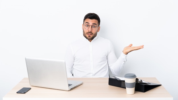 Young businessman in a workplace making doubts gesture