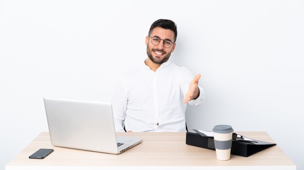 Young businessman in a workplace shaking hands for closing a good deal