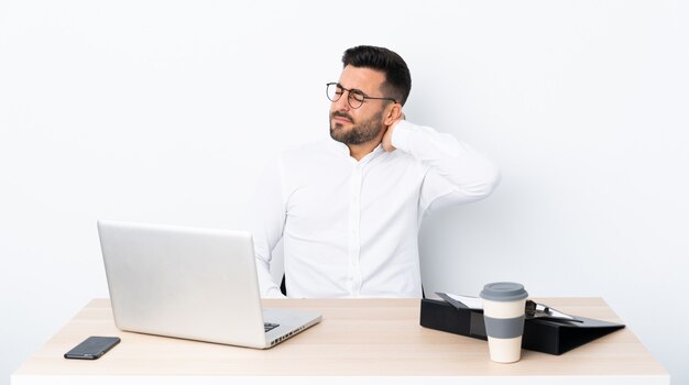 Young businessman in a workplace with neckache