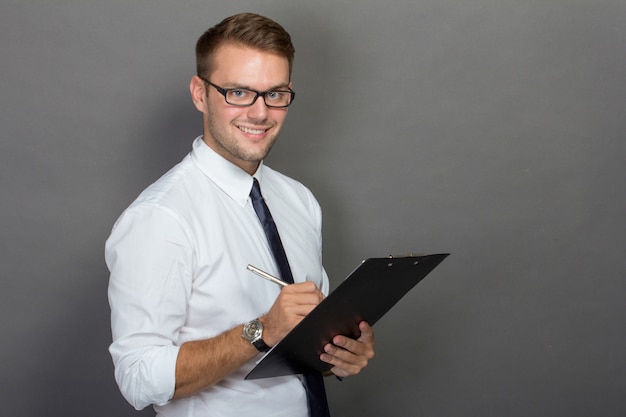 Young businessman writing on a clipboard