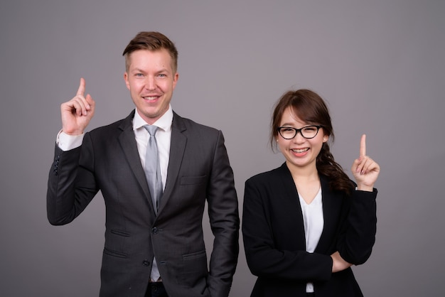 Young businessman and young Asian businesswoman together