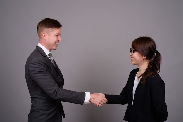 Young businessman and young Asian businesswoman together