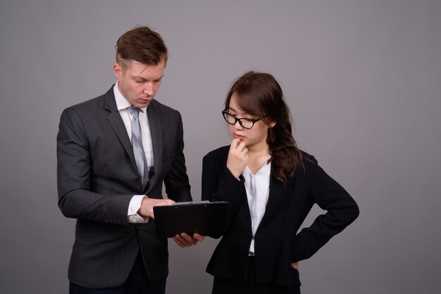 Young businessman and young Asian businesswoman together