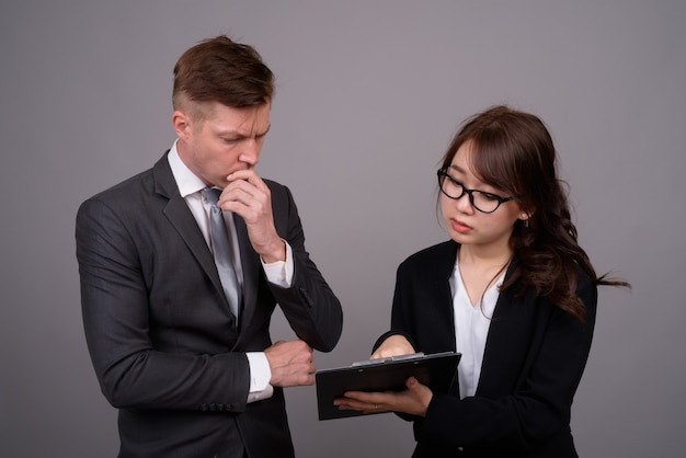 Young businessman and young Asian businesswoman together