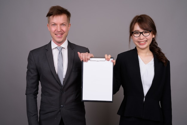 Young businessman and young Asian businesswoman together