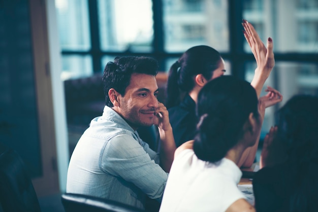 Young businessmen are looking at colleagues while meeting.