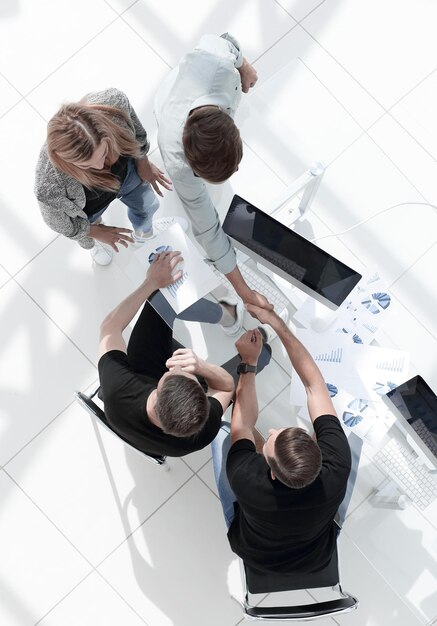 Young businessmen in a modern office sign a contract and shake hands with each other