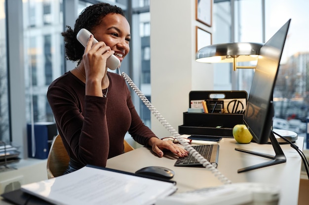 Young businesswoman answering phone calls at desk