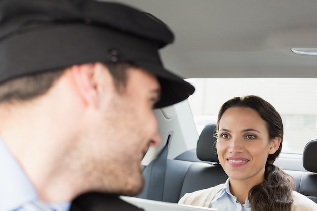 Young businesswoman being chauffeured while working