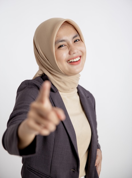 Young businesswoman cheerful pointing at the camera isolated white wall