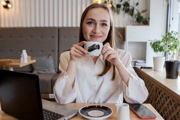 Young businesswoman on a coffee break. Using tablet computer