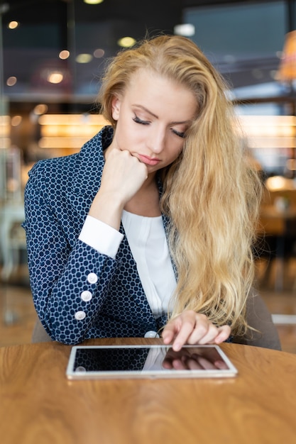 Young businesswoman on a coffee break. Using tablet computer.