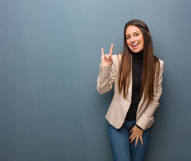 Young businesswoman doing a rock gesture