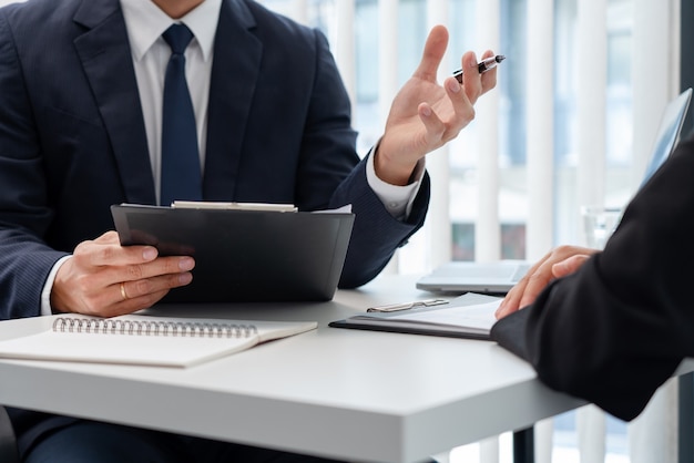 写真 彼女のプロフィールについて説明し、企業の会議中に履歴書を保持している若い実業家