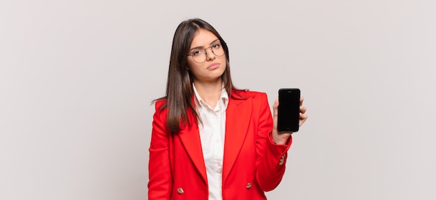 Young businesswoman feeling sad, upset or angry and looking to the side with a negative attitude, frowning in disagreement