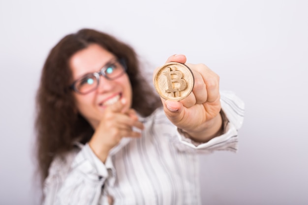 Photo young businesswoman holding a golden bitcoin