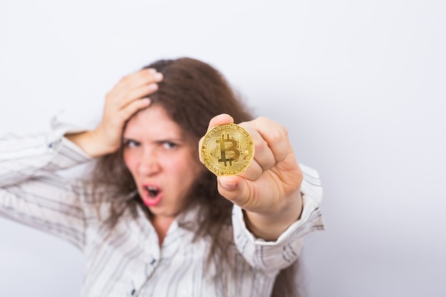 Giovane imprenditrice tenendo un bitcoin dorato