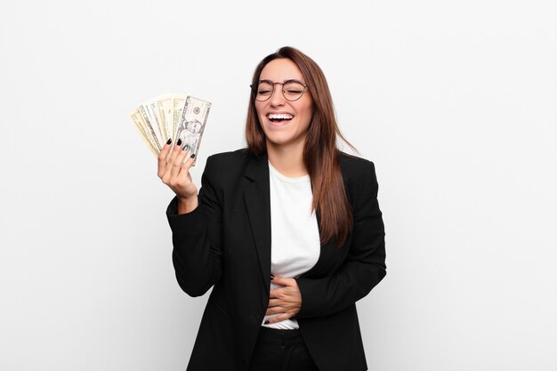 young businesswoman holding money and laughing