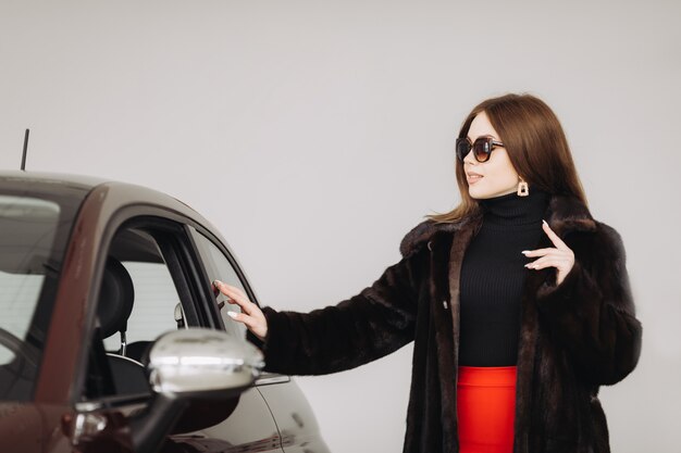 A young businesswoman is testing cars in a car store