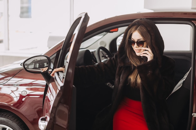 A young businesswoman is testing cars in a car store