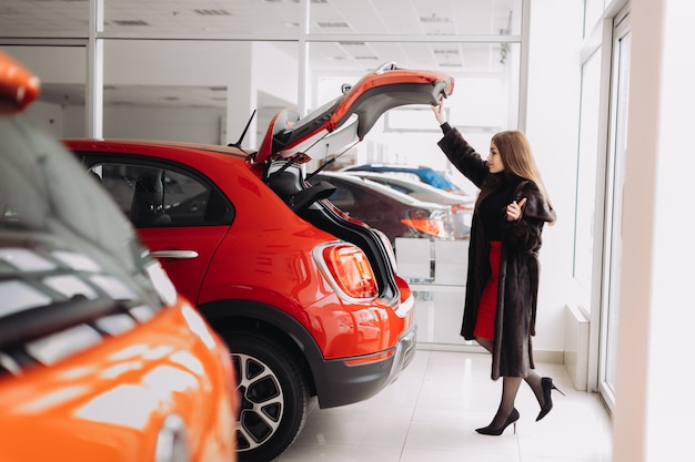 A young businesswoman is testing cars in a car store