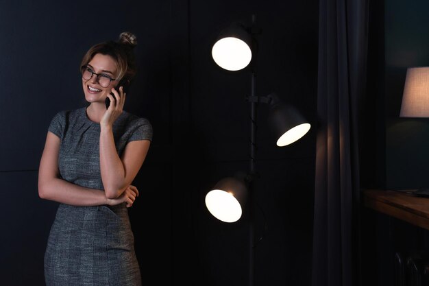 Young businesswoman is using smartphone  during late night work in office