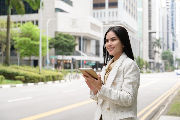 Una giovane donna d'affari sta lavorando nella moderna città del centro di singapore