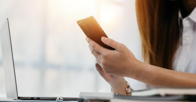 Young businesswoman looking at financial information from a\
mobile phone she is checking company financial documents she is a\
female executive of a startup company concept of financial\
management