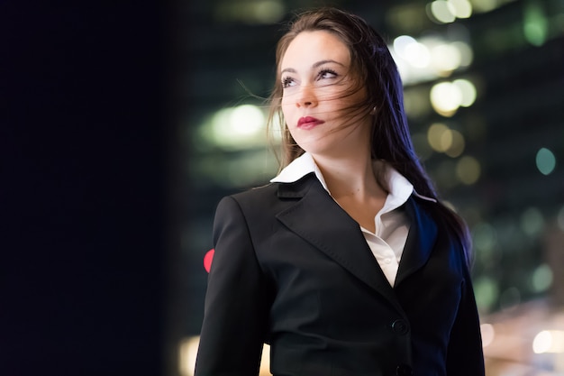 Young businesswoman portrait in a modern city setting at night