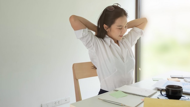 写真 彼女の机でリラックスした若い実業家