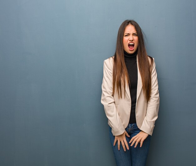 Young businesswoman screaming very angry and aggressive