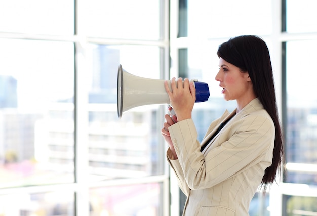 Photo young businesswoman shouting through megaphone