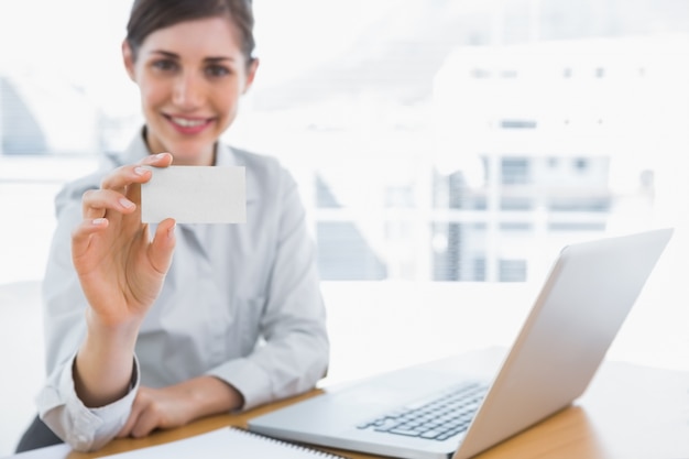 Young businesswoman showing blank business card