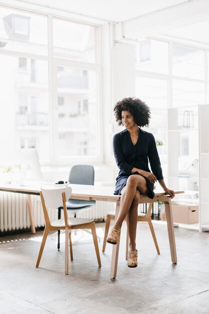 Young businesswoman sitting on her desk