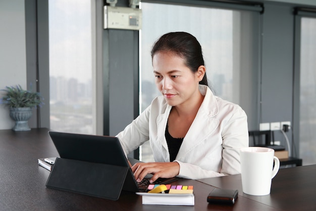 Young businesswoman sitting at the table on workplace in office