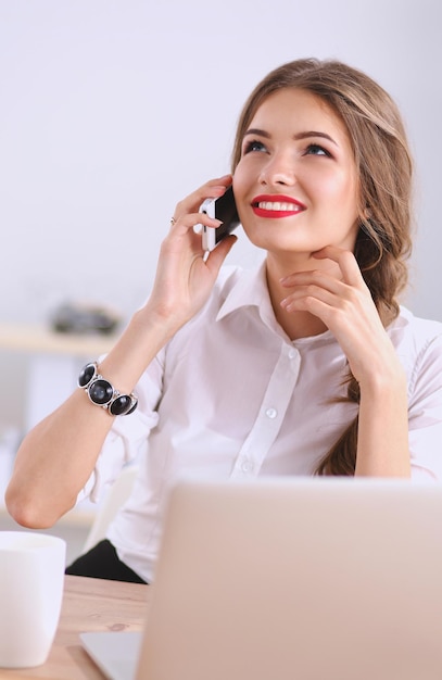 Young businesswoman sitting and talking on phone