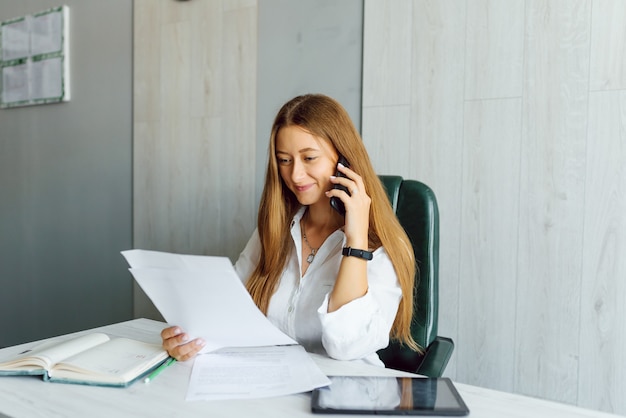 Young businesswoman sitting at workplace in office