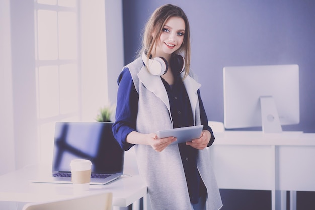 Young businesswoman standing in front of a table in the office