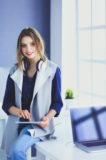 Young businesswoman standing in front of a table in the office