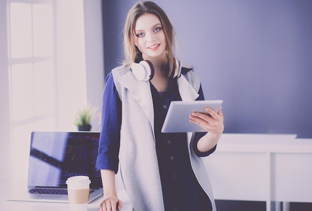 Young businesswoman standing in front of a table in the office