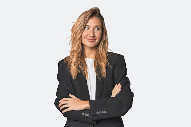 Young businesswoman in a suit smiling confident with crossed arms